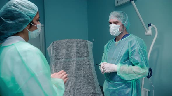 Surgeon Talk with a Patient Before Procedure Wearing Protective Gloves and Gown