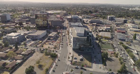 Smooth aerial orbit revealing the heart of Dandenong commercial zone parallel to the transport hub.