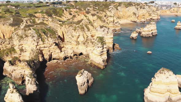 Little beachlets and caves carved into ochre cliffs by the Algarve sea, in Lagos, Portugal