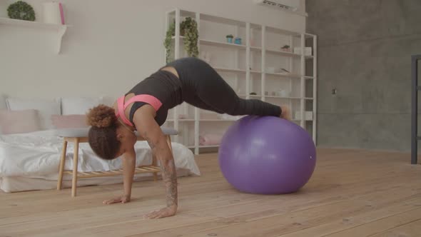 Sporty African Woman Doing Fitball Pike Exercise