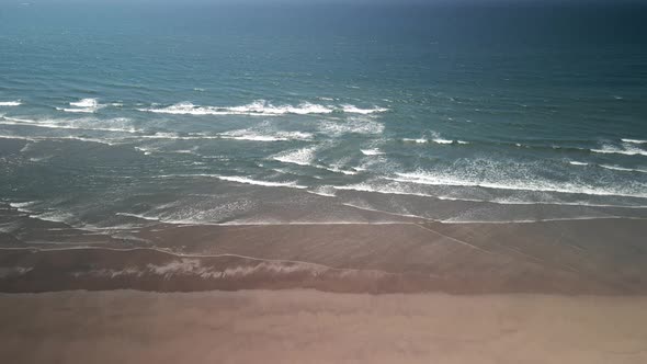 Bird'seye View of the Ocean and the Sandy Beach at Sunset