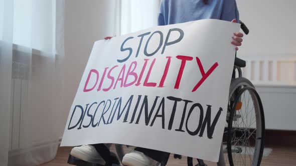 A Disabled Attractive Woman is Showing a Poster and Looking to the Camera