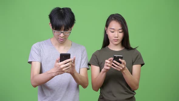 Young Asian Couple Using Phone Together