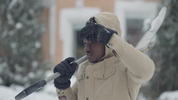 Portrait of Perspiring African American Man Wiping Forehead After Cleaning Snow at Backyard and