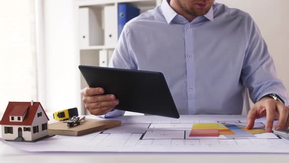 Architect with Tablet Pc, Blueprint and Palettes 