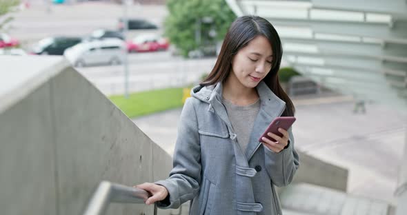 Woman work on smart phone in city