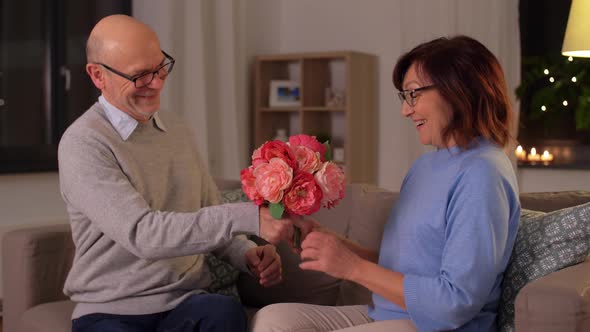 Happy Senior Couple with Bunch of Flowers at Home