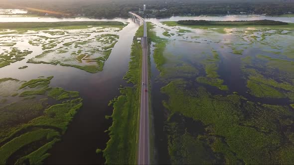 Drone flying over causeway revealing bridge at sunset in Ocean Isle Beach, NC