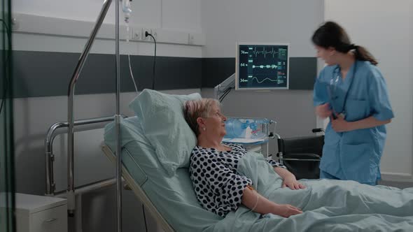 Medical Assistant Putting Oximeter on Finger of Aged Patient