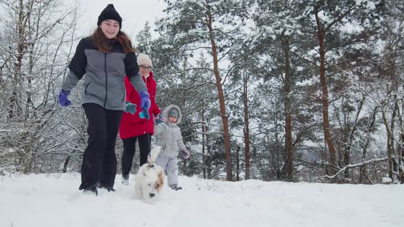 Happy Family Play with Dog Jack Russell Terrier In Snowy Day In Forest