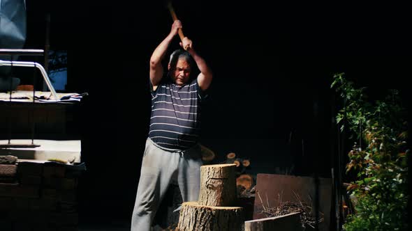 Angry Man Chopping Wood at Night