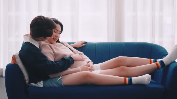 Pregnant Asian lesbian woman and her partner are happy to spend time together at home.