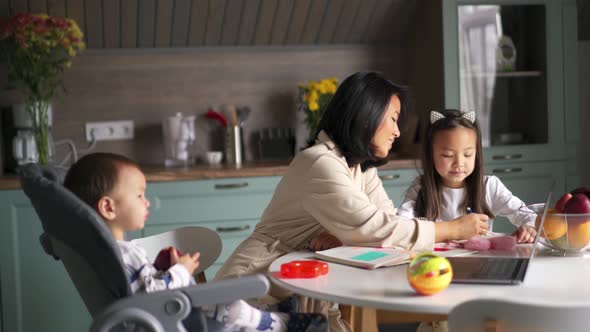 Positive Asian family painting in the kitchen