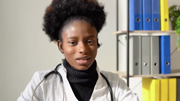 Young African American Woman Doctor Having Chat or Consultation on Laptop Looking Directly to the