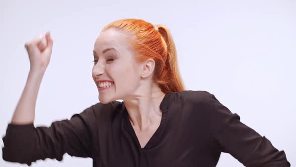 Middleaged Caucasian Woman in Dark Brown Shirt with Colored Orange Hair Actively Rejoicing and