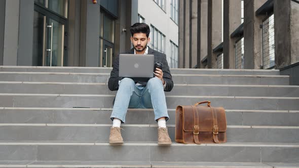 Confident Hindu Man in Stylish Clothes Working on Wireless Laptop Outdoors