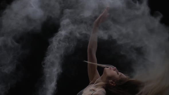 Close-up Slow Motion, Graceful Maiden Throwing Dust Particles in Air on Black Background