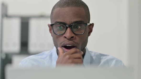 Close Up of African Man Feeling Shocked While Using Laptop