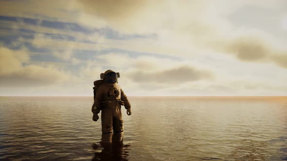 Spaceman in the Sea Under Clouds at Sunset