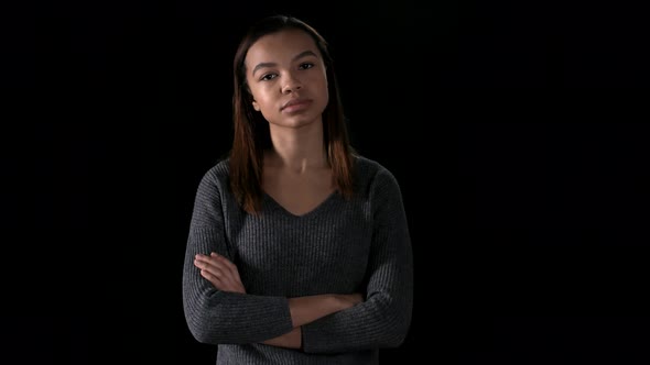 Portrait of African Woman against Black Wall