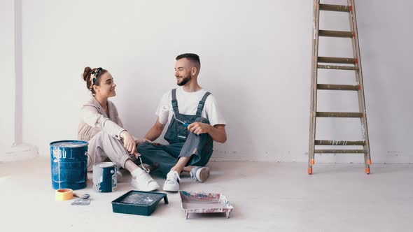 Happy Couple Painting Their First Apartment Together