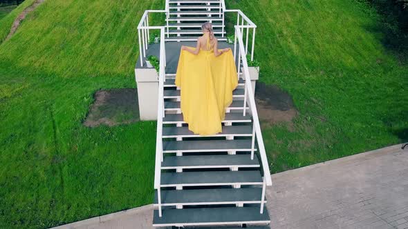 Aerial Shot Young Charming Girl in a Beautiful Yellow Fluttering Evening Dress