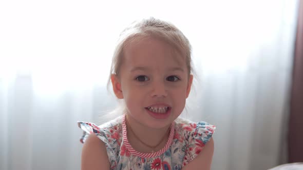 Authentic Cute Preschool Minor Little Child Girl in Dress Looking at the Camera and Smiling While