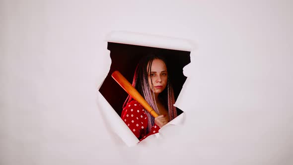 Young Woman with Baseball Bat in Hole of White Background