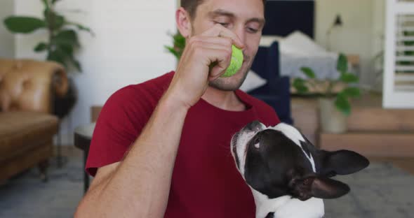 Caucasian man is playing with his dog at home