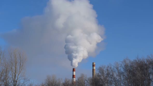 The pipe smokes against the blue sky