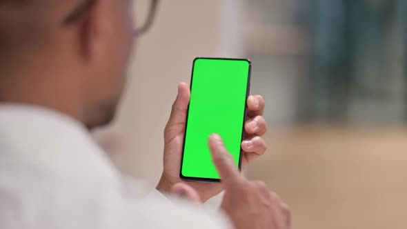 Rear View of Male African Doctor Using Smartphone with Chroma Screen