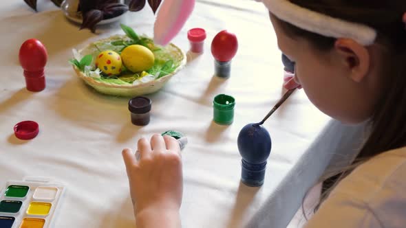 Child Girl Having Fun During Painting Eggs for Easter in Spring Time at Home