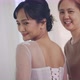 Asian Bridesmaid Ties And Helps Put On The Bride's Wedding Dress. - VideoHive Item for Sale