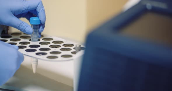 Female Scientist Doing Experiment in Laboratory. Scientist Holding Test Tube in Hands. alt