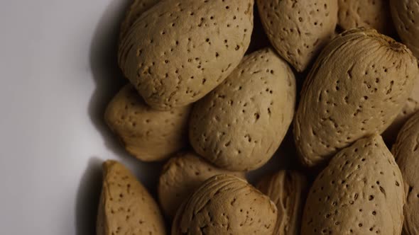 Cinematic, rotating shot of almonds on a white surface 