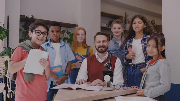 Male Teacher with Elementary School Children Looking at Camera and Smiling