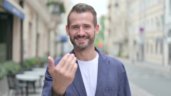 Outdoor Portrait of Man Pointing at the Camera and Inviting