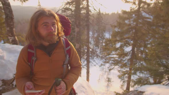 Man Using Map on Smartphone during Winter Hike