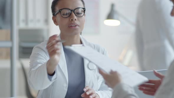 Female Doctor Giving Medical Service Agreement to Woman