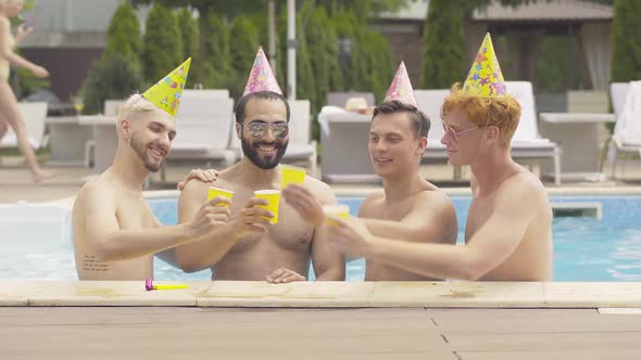 Positive Friends in Party Hats Congratulating Middle Eastern Groom on Stag-party. Portrait of