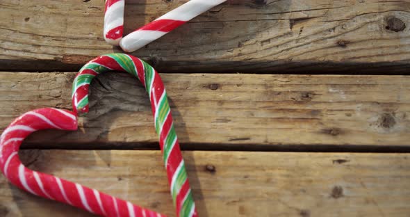 Candy cane with heart shape arranged on wooden table 4k