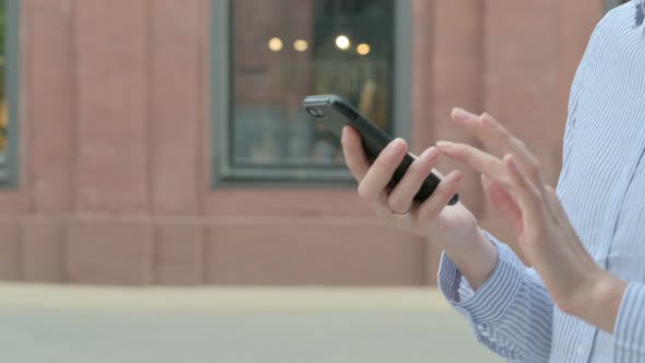 Woman Using Smartphone While Walking in Street