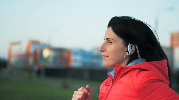 Young Woman Running Outdoors in a City Park