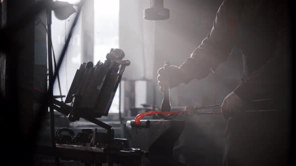 Blacksmith Workshop  a Man Shaping Heated Metal on an Anvil Using a Form and Pressing Machine