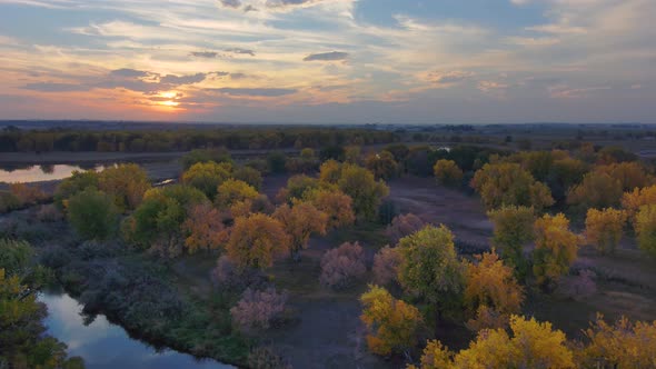 Autumn hues of amber and gold blend into the vivid sunset along the Platte river in Northern Colorad