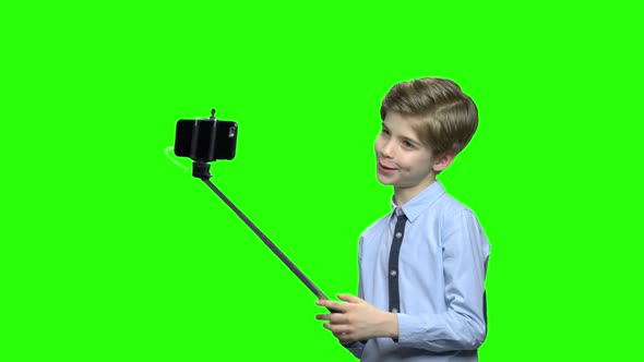 Cute Caucasian Boy with Selfie Stick Posing for Camera
