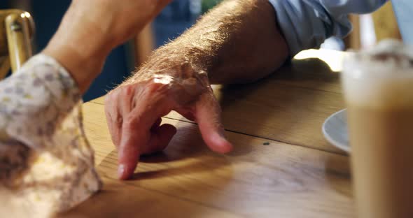 Senor couple holding hands in cafe 4k