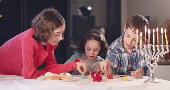 Kids playing with dreidels during Hanukka at home