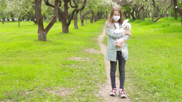 Little Girl with Dog Wearing Protective Medical Mask for Prevent Virus Outdoors in the Park