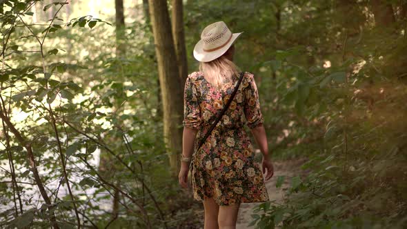 Relaxing Woman In Hat Walking Pine Forest. Holiday Vacation Tourist Journey Trip In Warm Day.